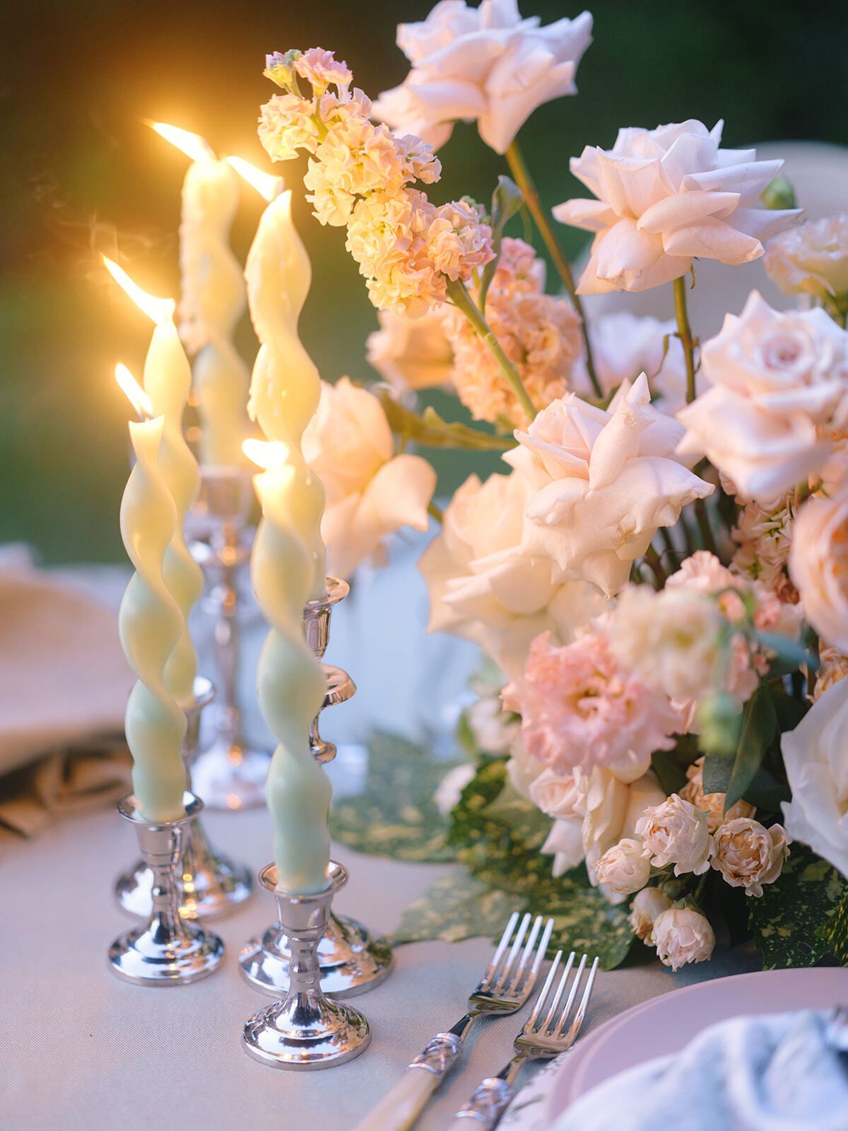 Candlelit table with pink roses at dusk