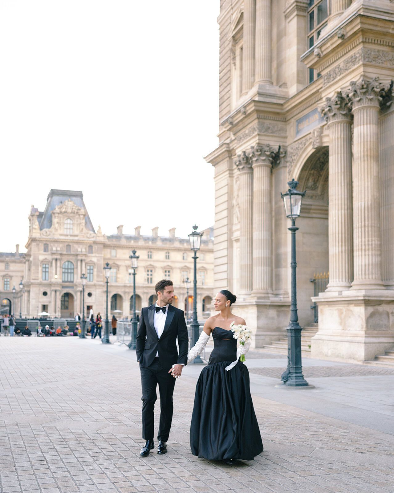 Paar geht an der Kolonnade des Louvre vorbei, Paris