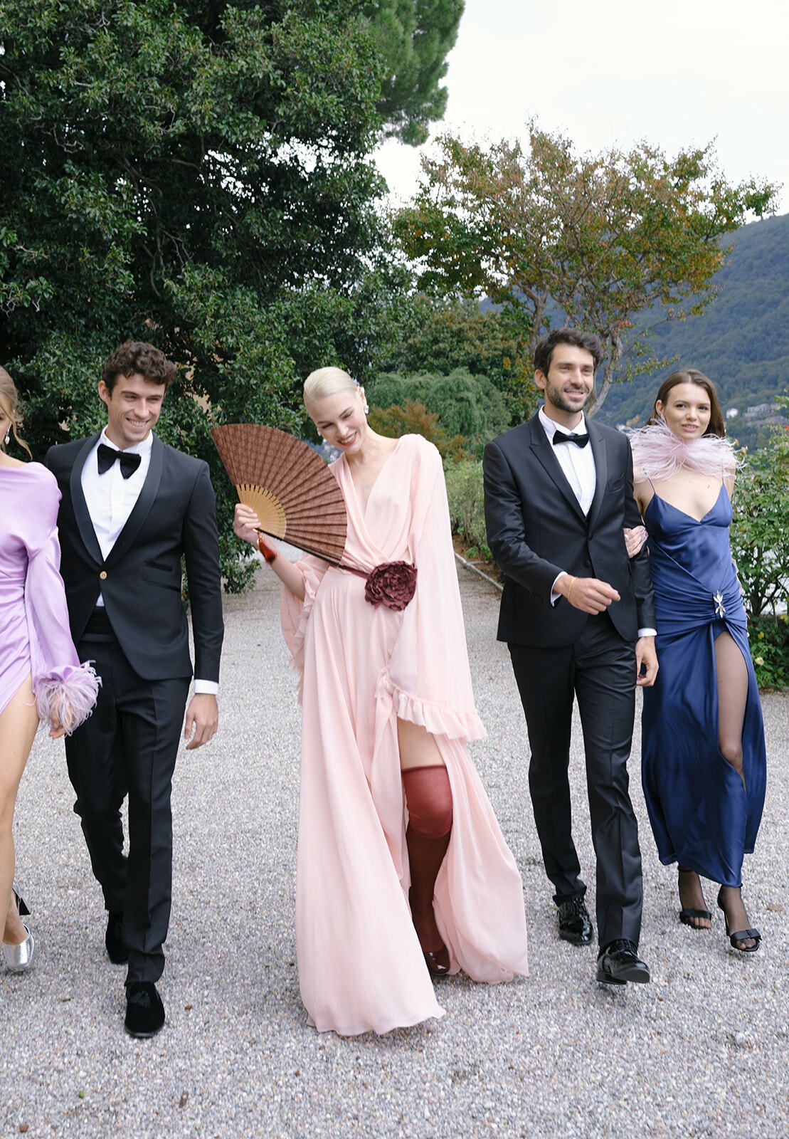 Invitados elegantes paseando por los jardines de Villa Pizzo