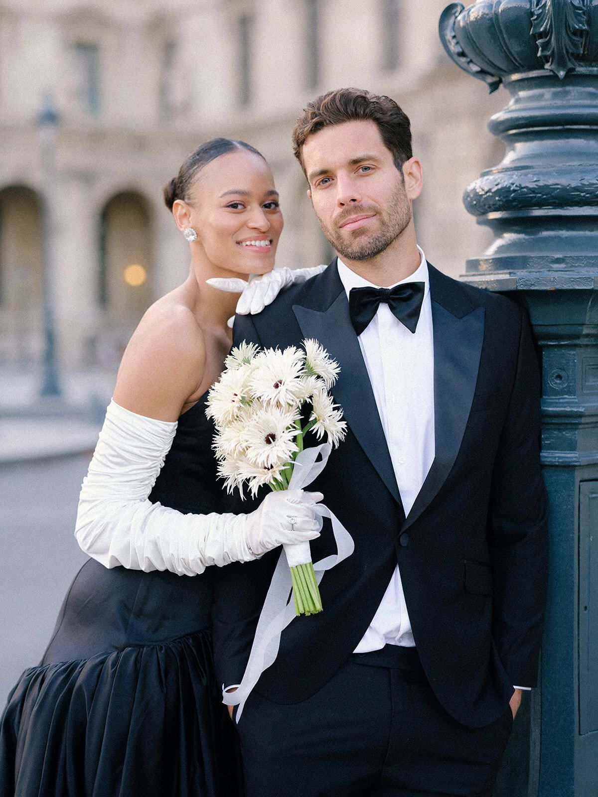 Braut in schwarzem Kleid lacht mit dem Bräutigam in Paris