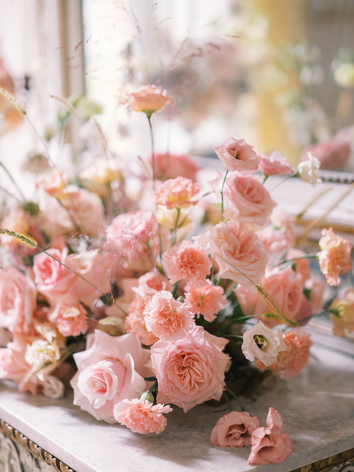 Rosas rosas en cascada sobre una mesa de mármol