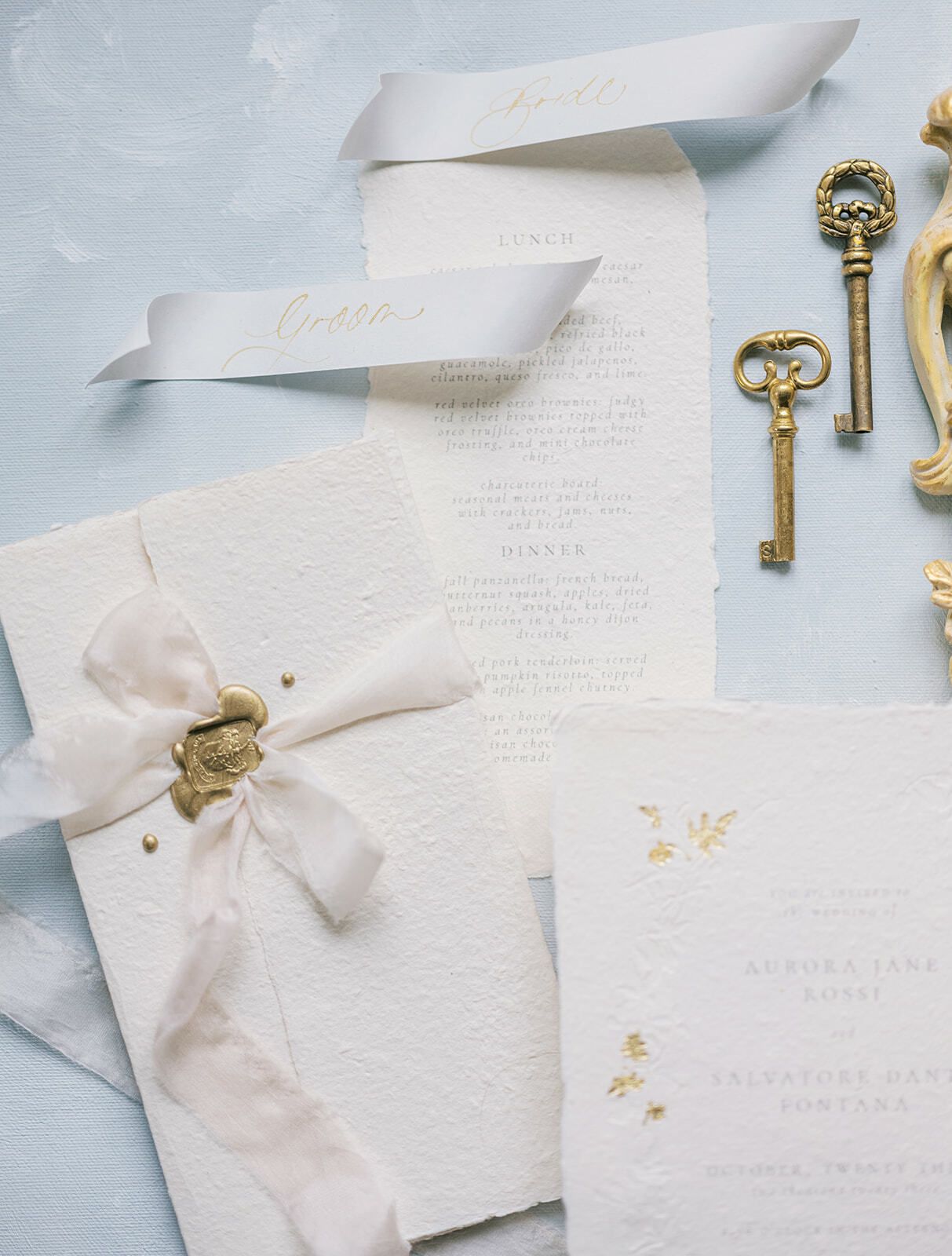 Papelería de boda con cinta de seda, sello de lacre y llaves antiguas