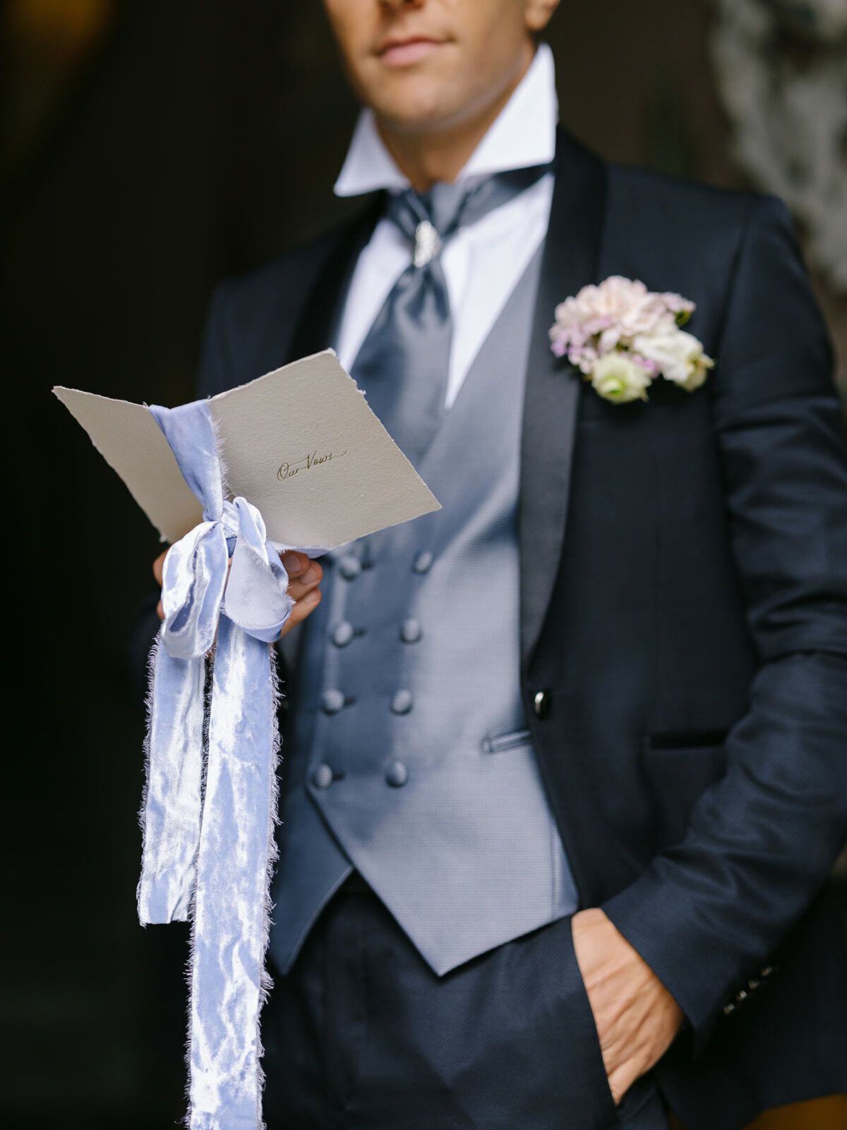 Novio sosteniendo una nota atada con cinta azul