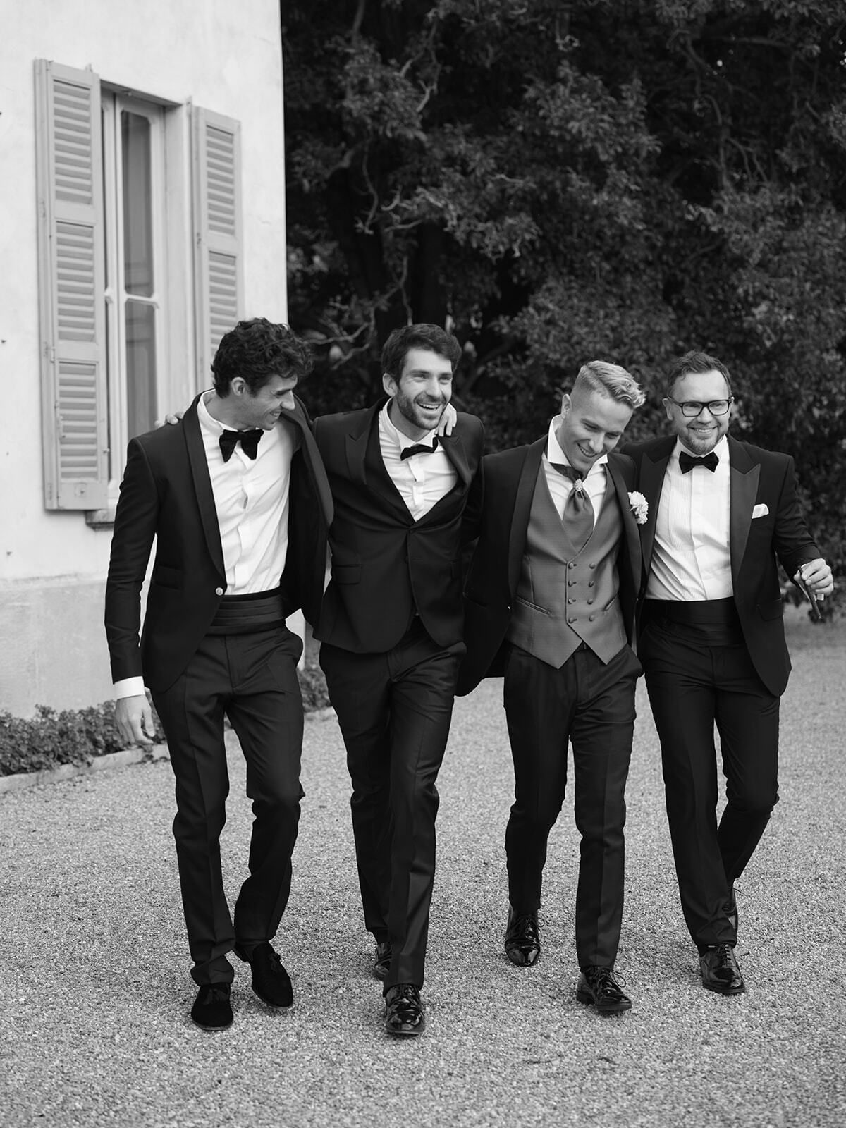 Foto en blanco y negro del novio y sus padrinos caminando juntos