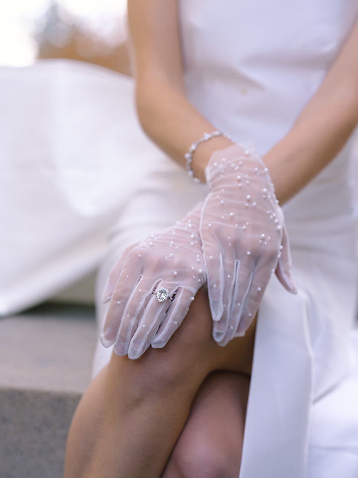 Nahaufnahme von Spitzenhandschuh und Armband einer Braut