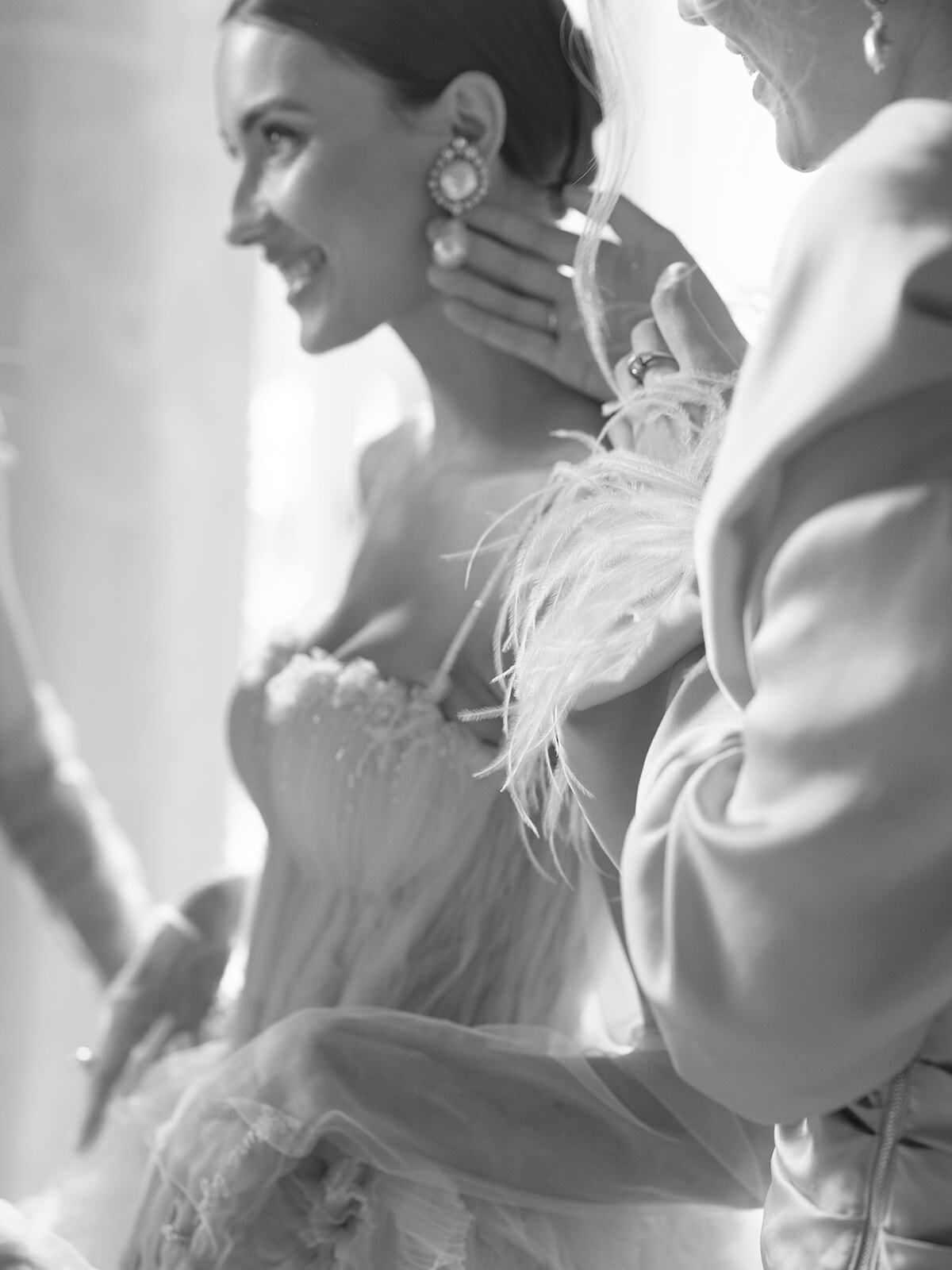 Foto en blanco y negro de una novia con pendientes de perla preparándose