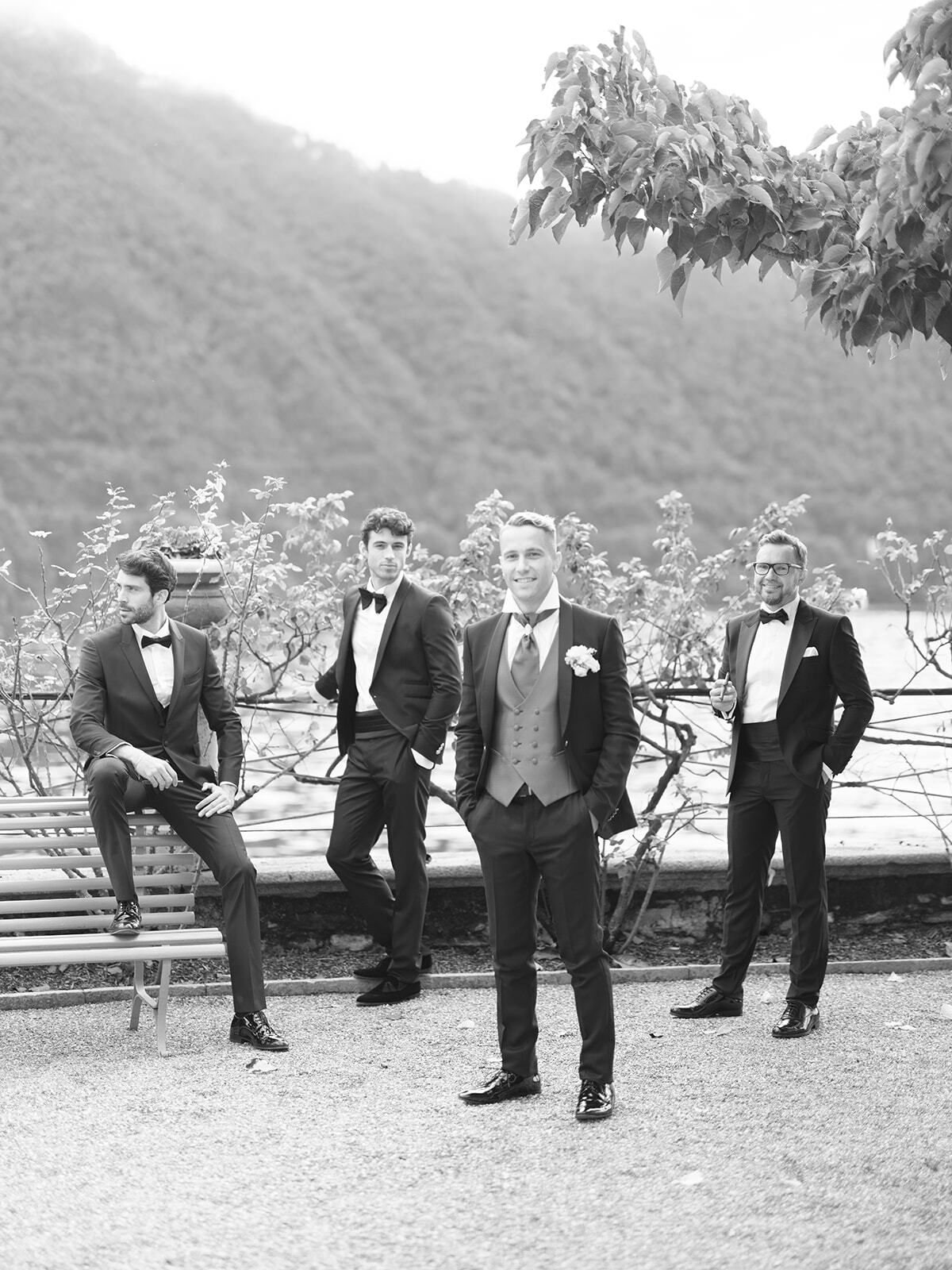 Foto en blanco y negro del novio y sus padrinos en el jardín