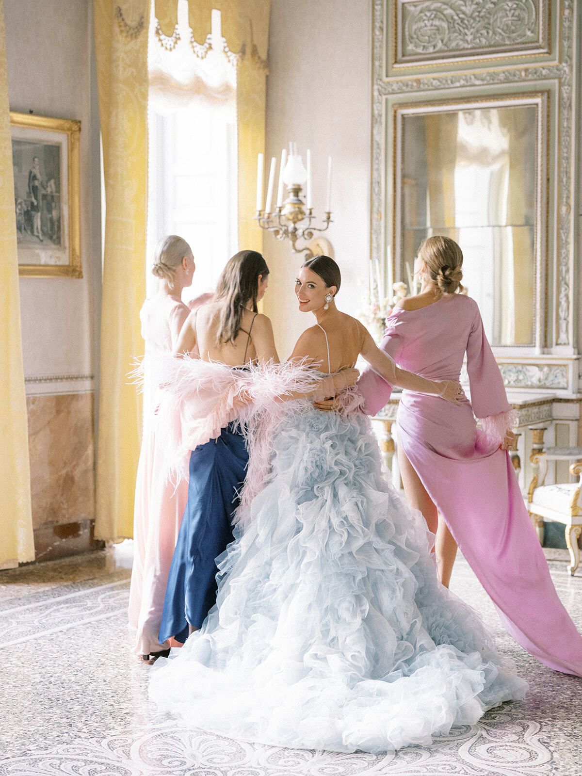 Damas de honor abrochando el vestido de tul azul de la novia, Villa Pizzo