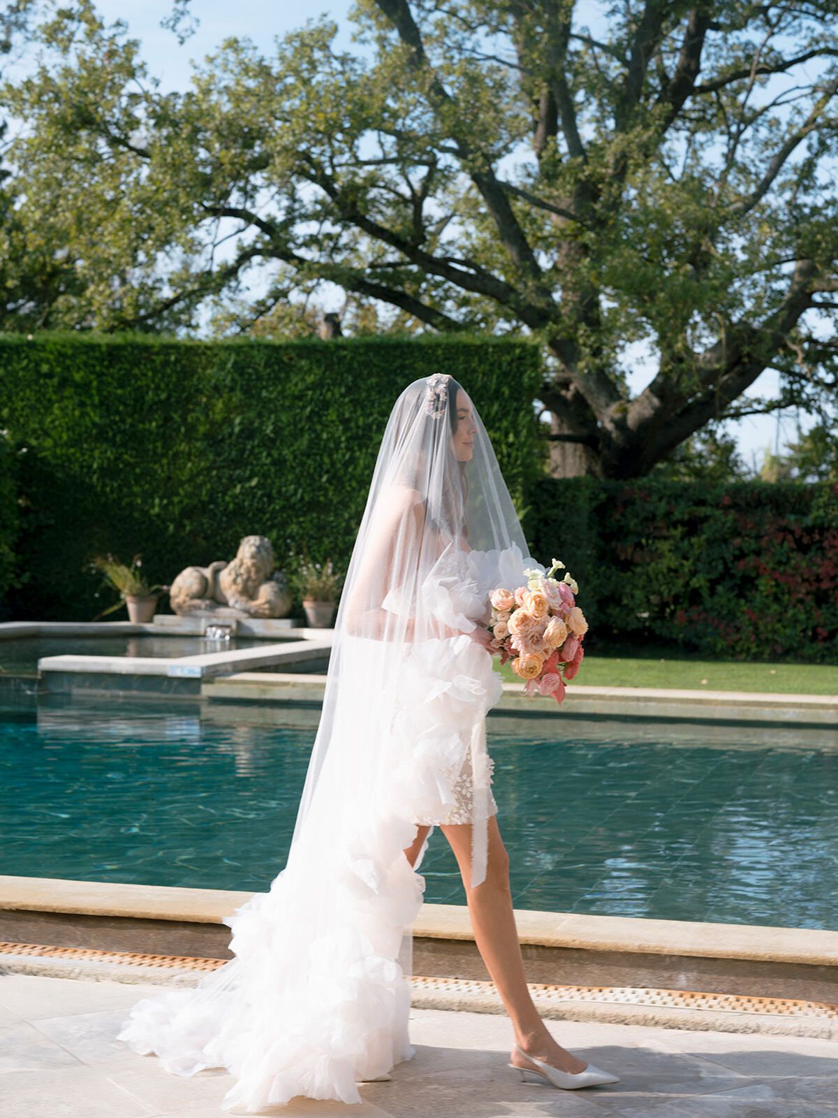Sposa con velo e abito corto a balze a bordo piscina, Château de Tourreau