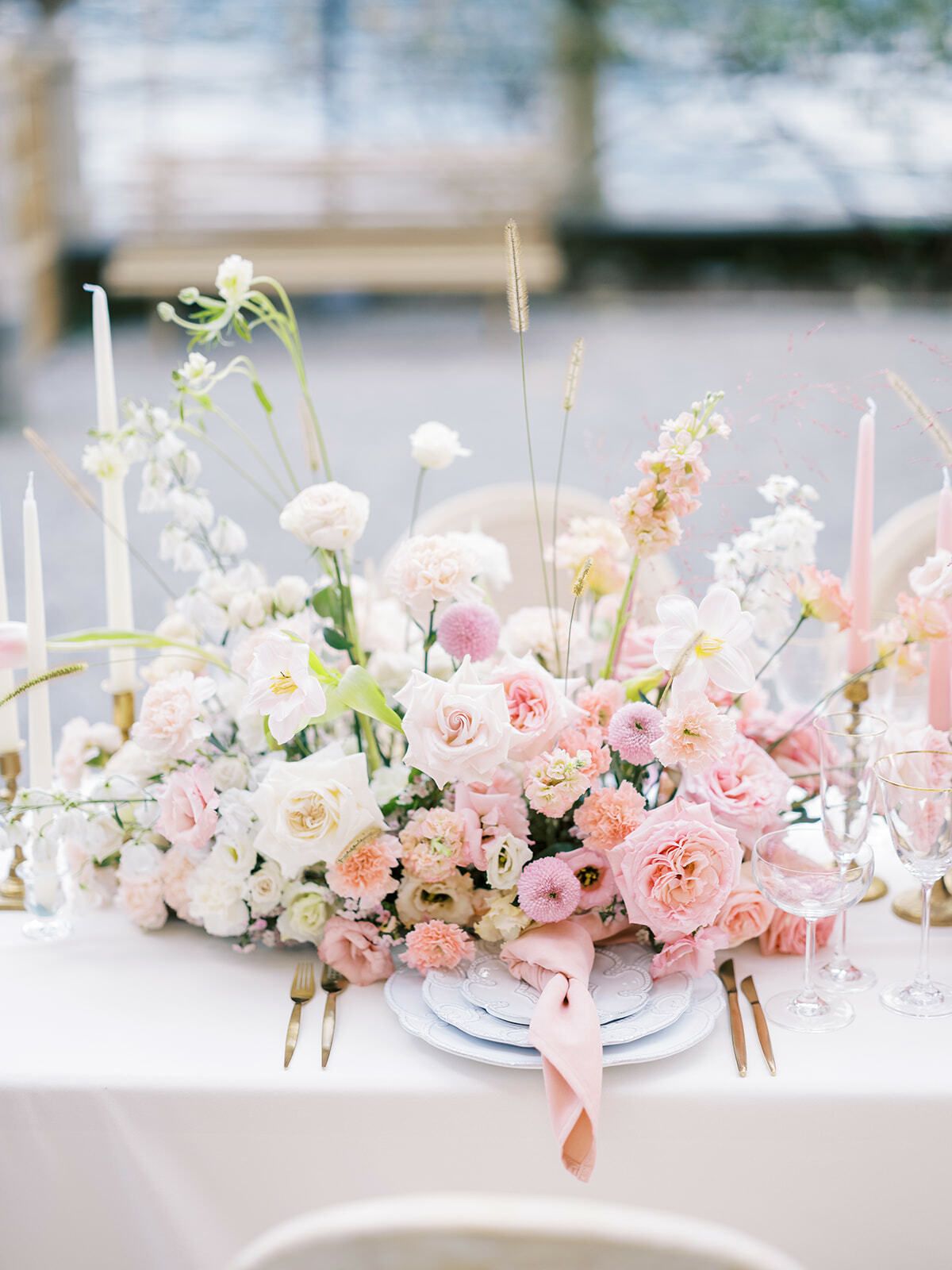 Centro de mesa floral rosa y blanco en una mesa de boda