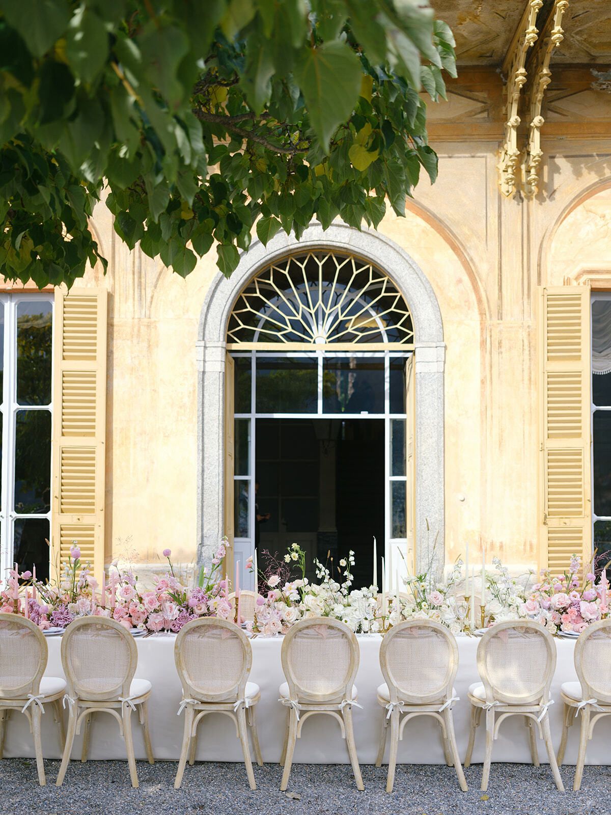 Mesa del banquete bajo los ventanales en arco de Villa Pizzo