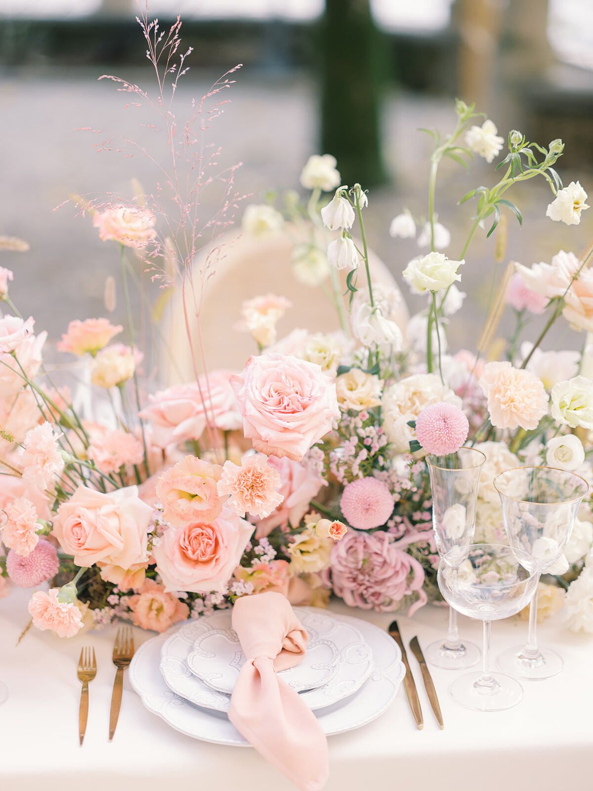 Centro de mesa floral rosa y melocotón en la mesa de boda