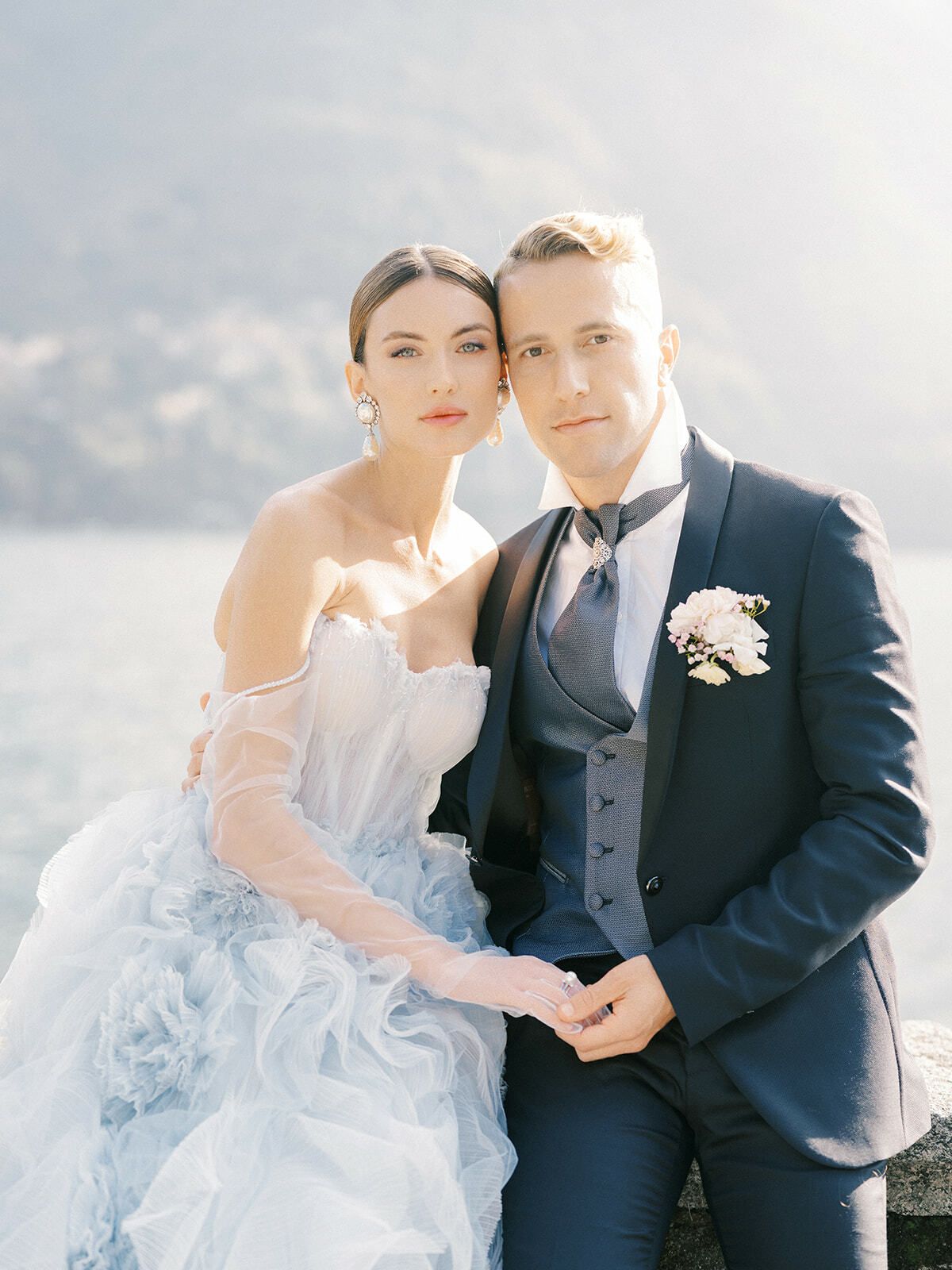 Novia con vestido de volantes azul pálido y novio junto al lago de Como