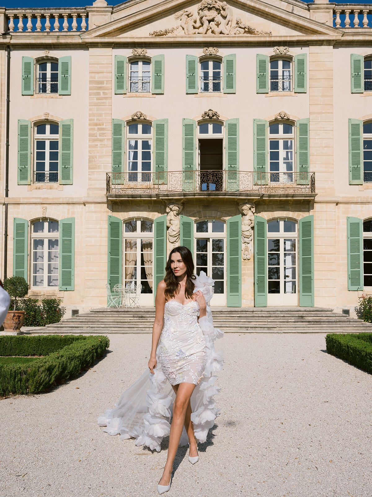 Novia con vestido asimétrico de volantes ante el Château de Tourreau