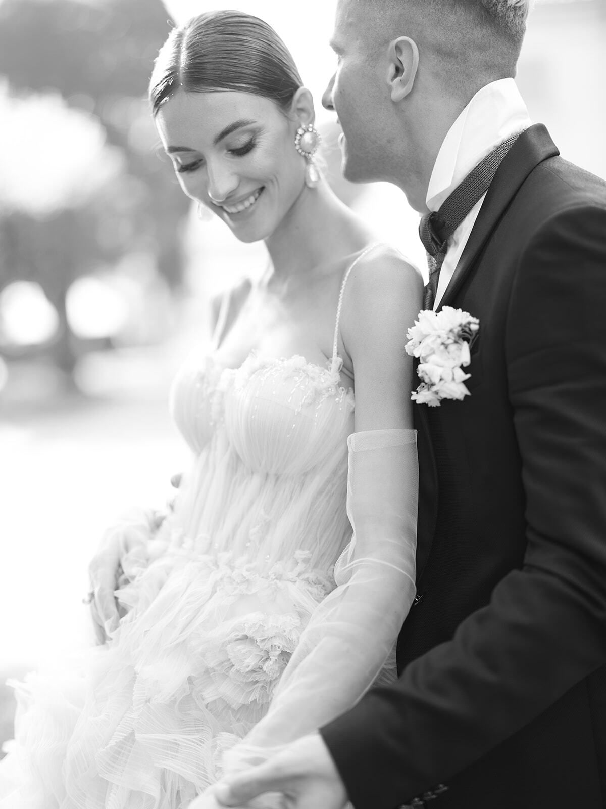 Foto en blanco y negro de la novia sonriendo junto al novio